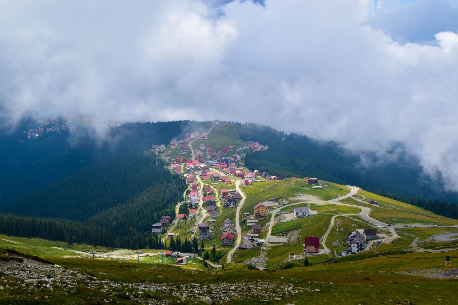 A small village is sitting on top of a hill in the mountains. transalpina