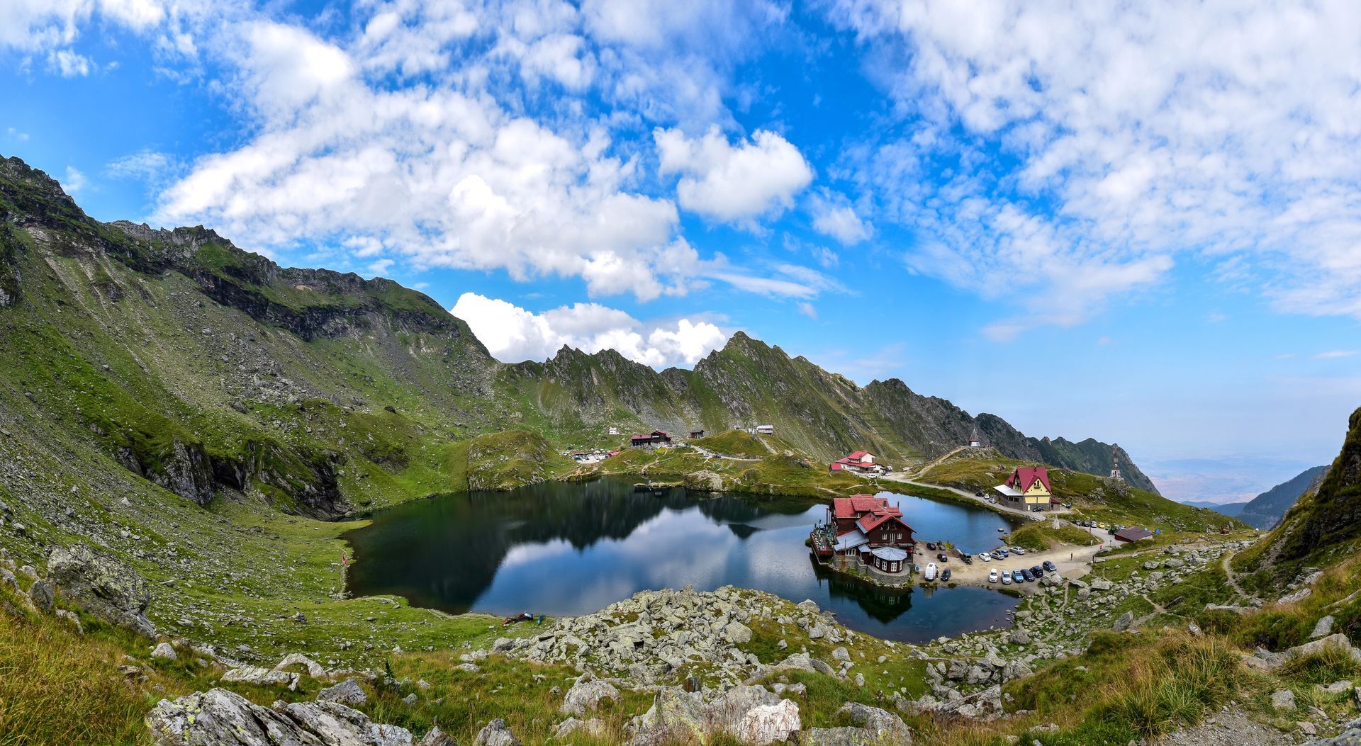 A lake in the middle of a mountain surrounded by mountains.