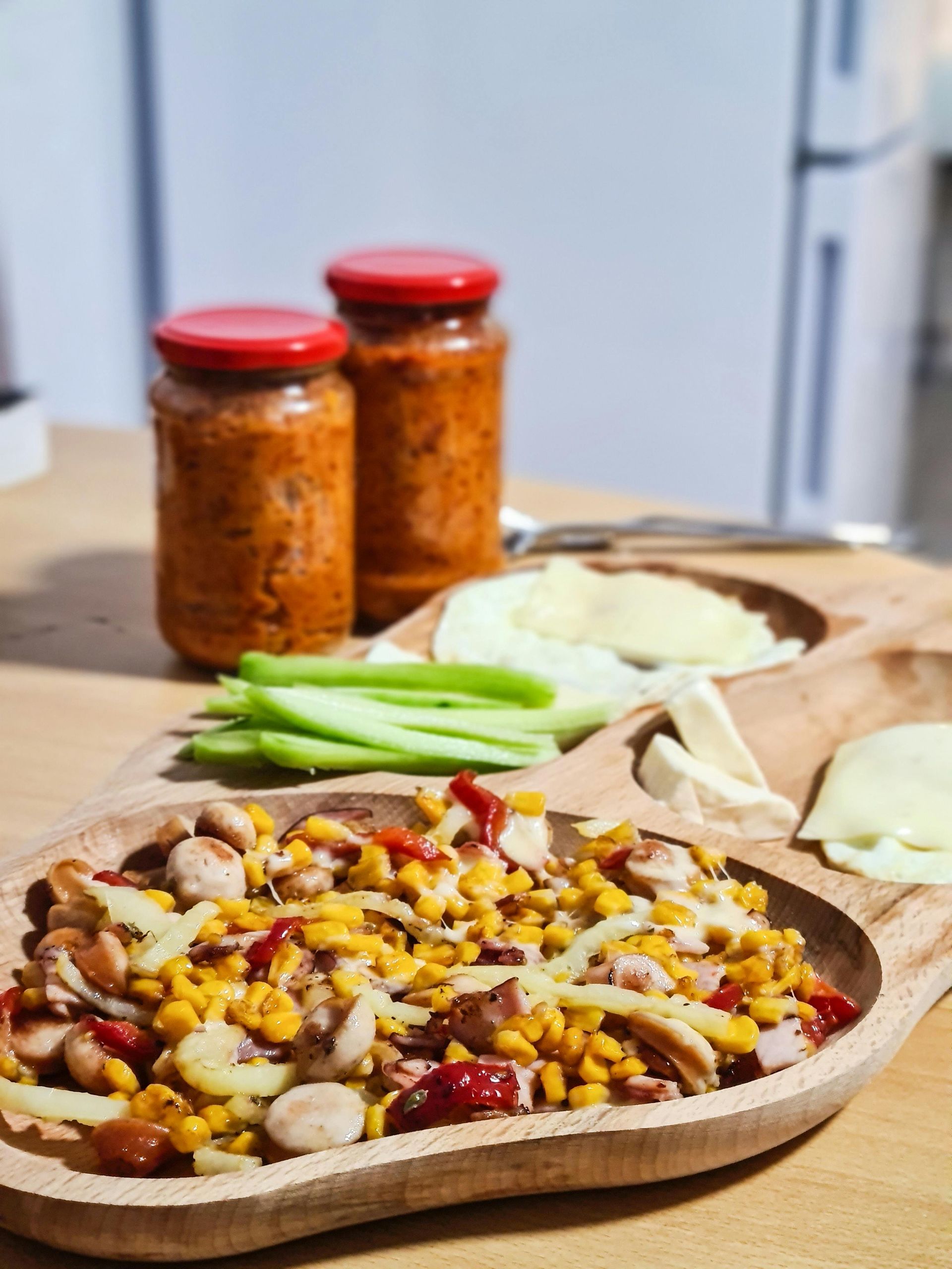 A wooden bowl filled with food is on a wooden table.