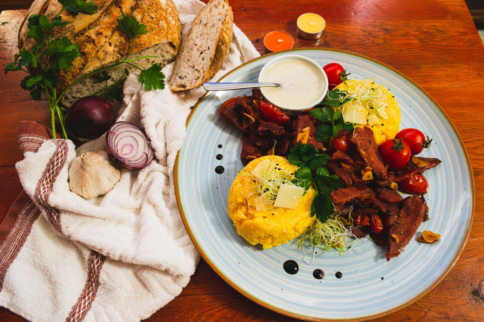 A plate of food with meat and vegetables on a wooden table.