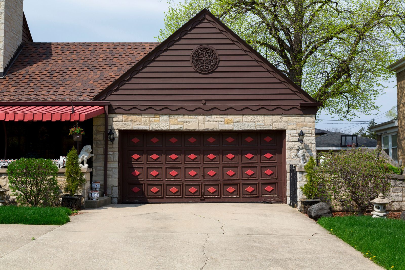A large brown garage door is in front of a house.