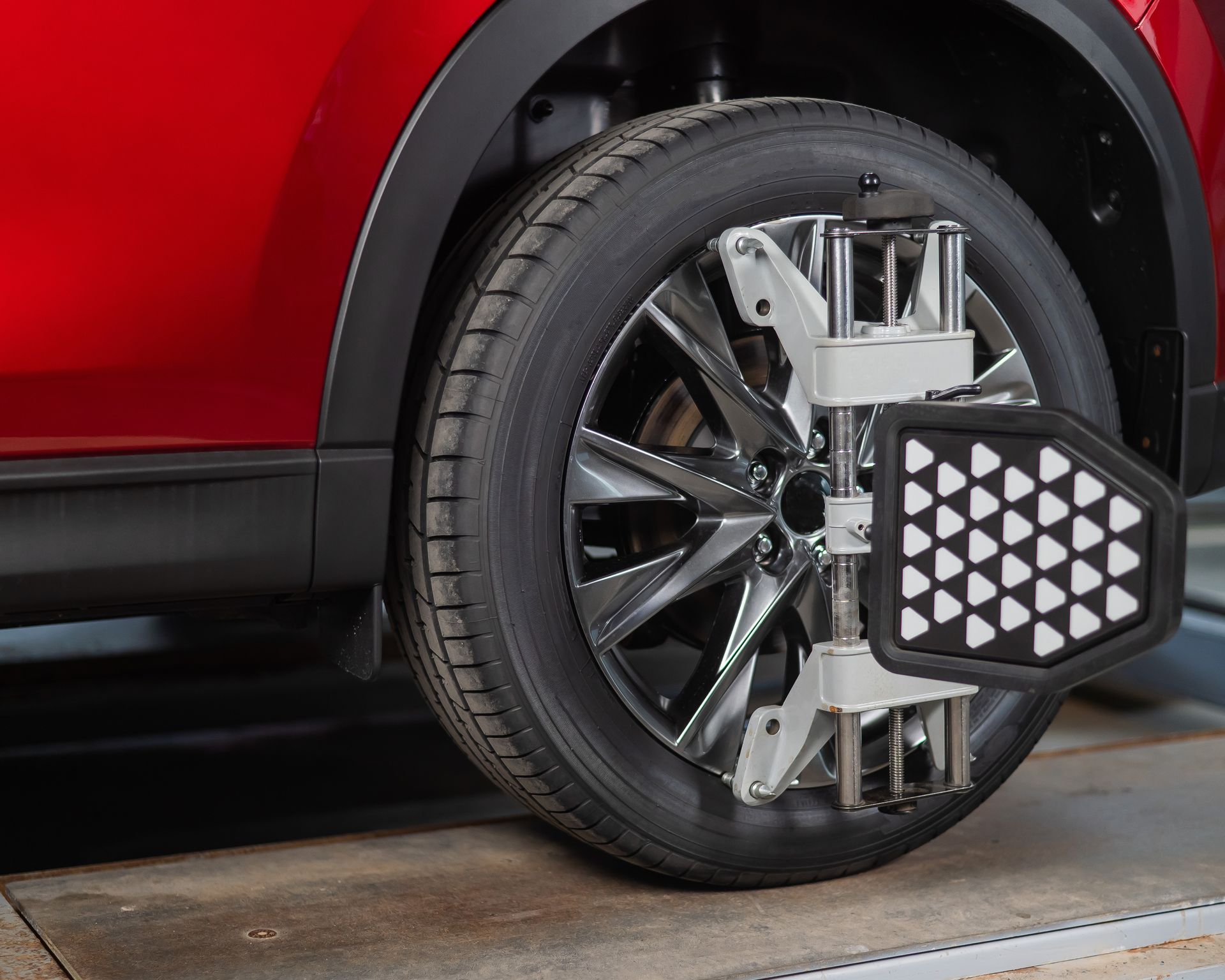 A red car is being adjusted by a machine.