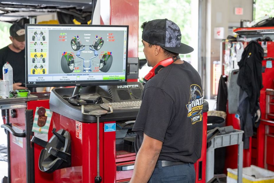 Worker welding metal on a truck chassis, sparks flying in a dark workshop | Motorvation Service Center