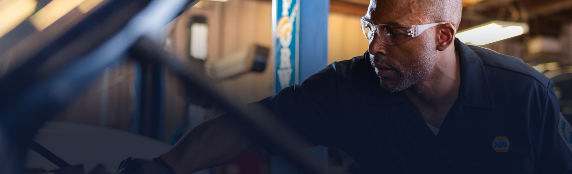 Man wearing glasses looks at a computer monitor in a dimly lit office | Motorvation Service Center