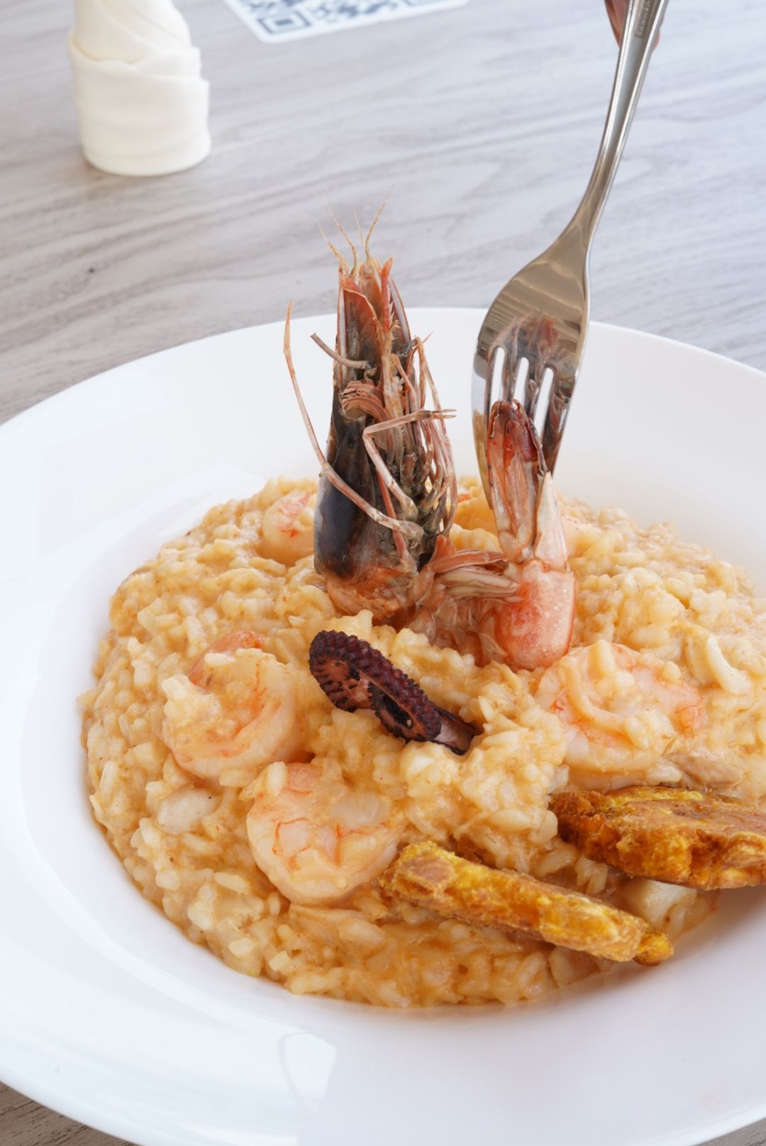 Una persona sostiene una sartén con comida en su mano.