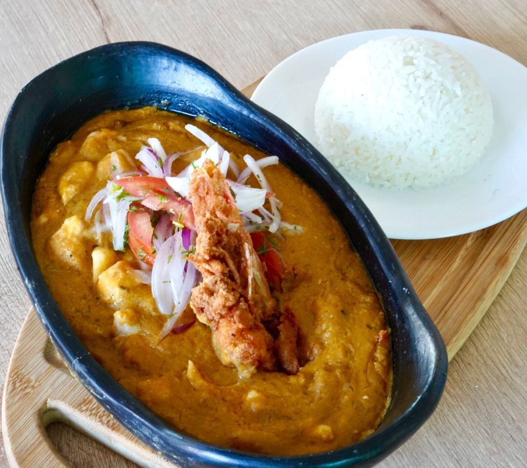Un tazón de curry junto a un plato de arroz