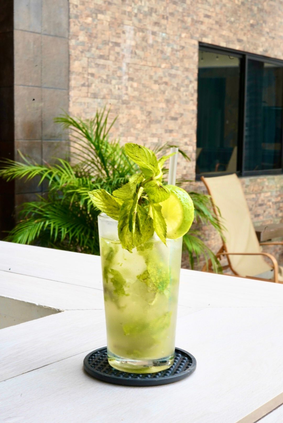 Un vaso de mojito con una pajita sobre una mesa.
