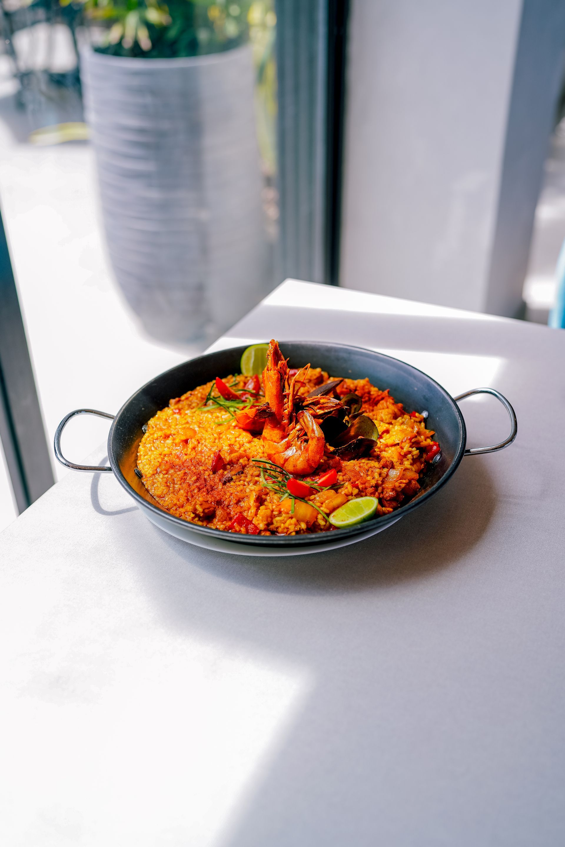 Un plato de comida con huevos, tomates y un vaso de jugo de naranja sobre una mesa.