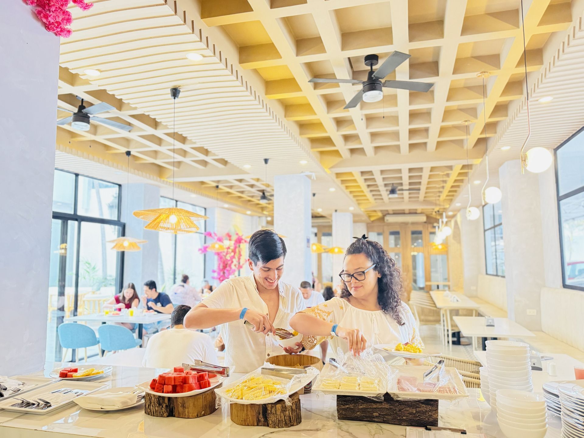 Una tabla de cortar de madera larga llena de comida frita y verduras.