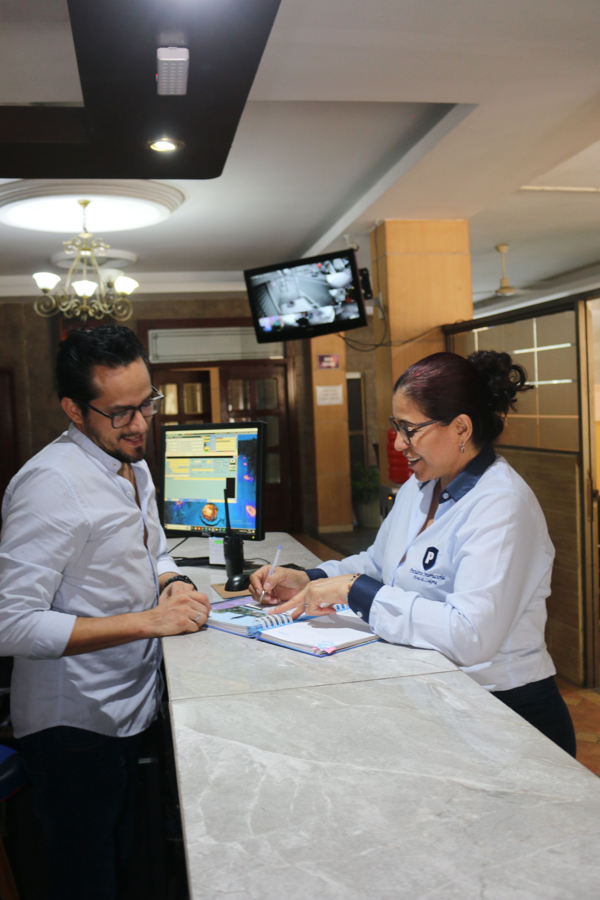 Un hombre está hablando con una mujer en un mostrador de un hospital.