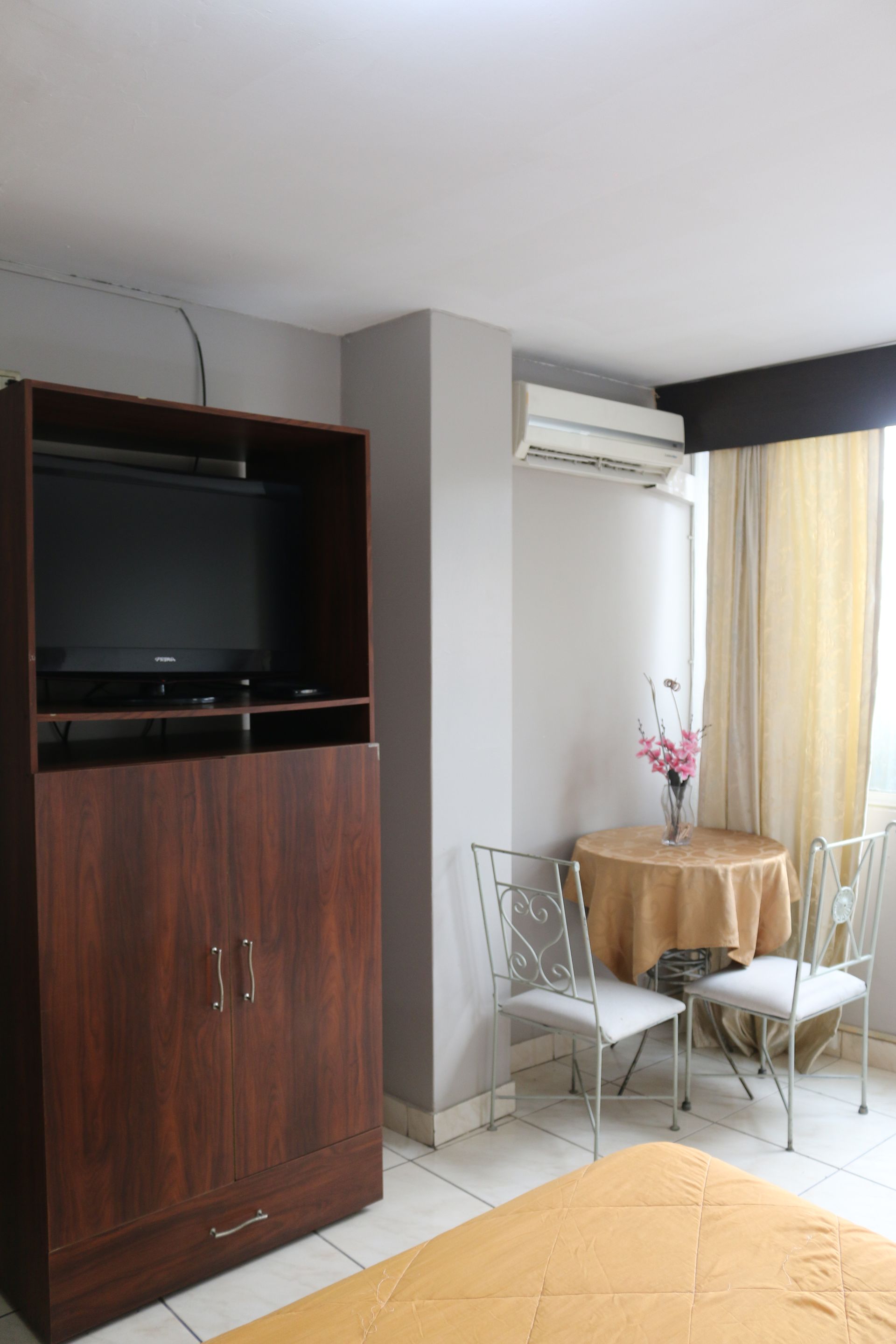 Un dormitorio con una mesa y sillas y un televisor de pantalla plana.