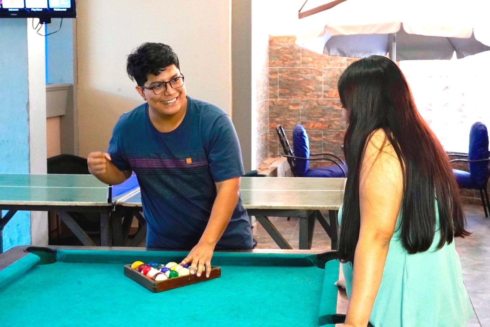 Un hombre y una mujer están jugando al billar juntos