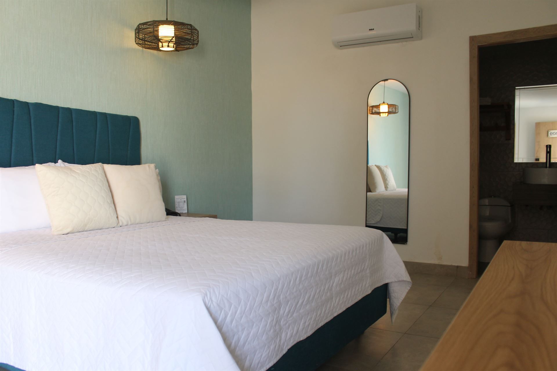 Una habitación de hotel con una cama grande y un espejo.