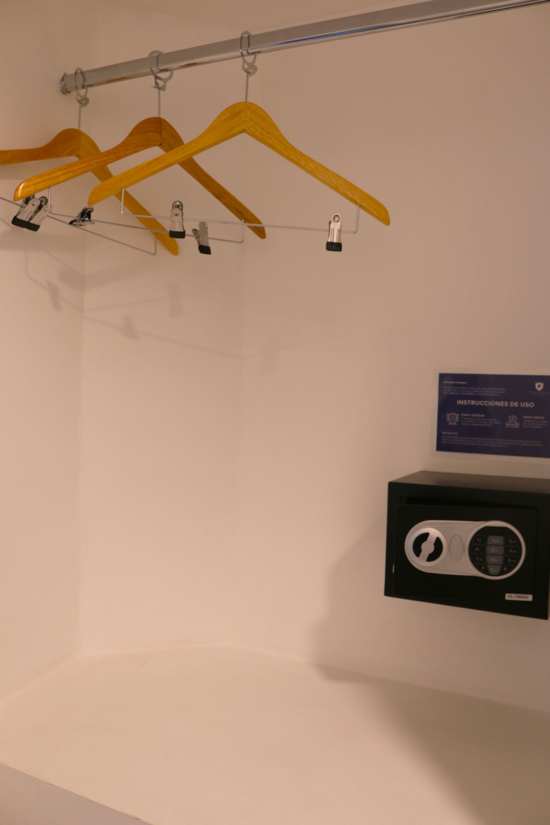 Ropa colgada en un perchero junto a una caja fuerte