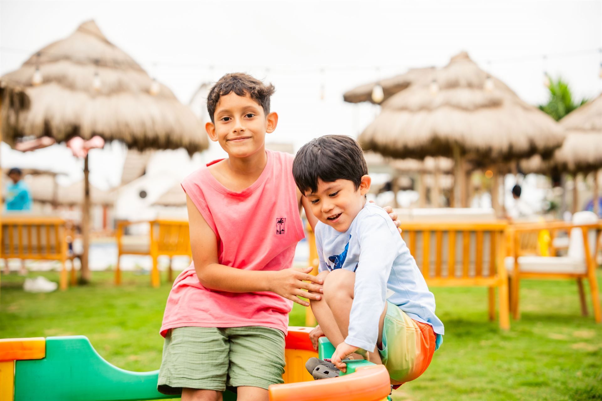 Dos niños pequeños están jugando en un balancín en un parque.
