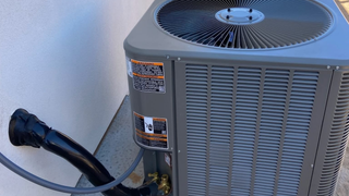 A large air conditioner is sitting on the side of a building.