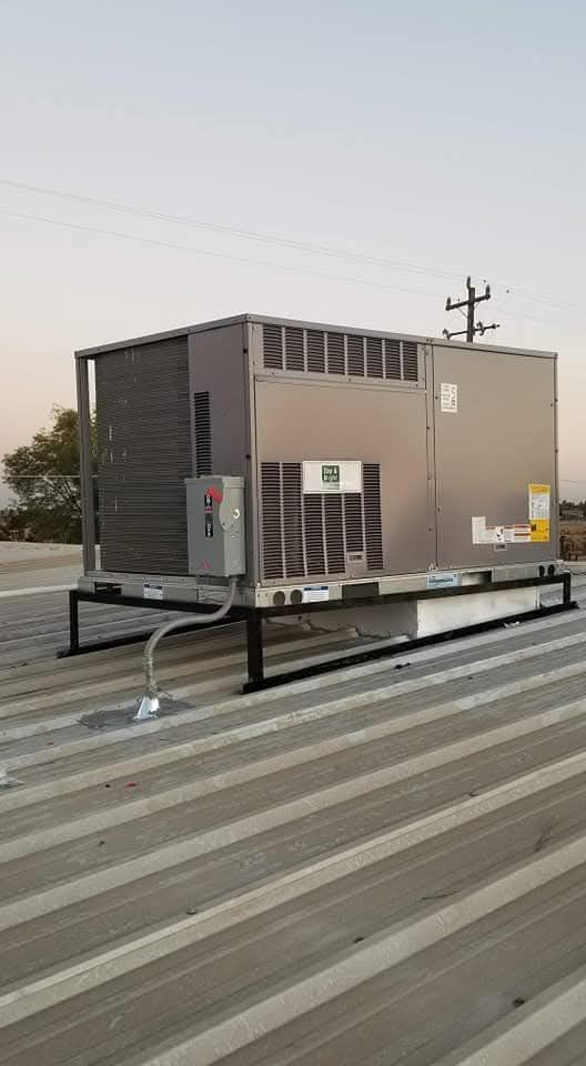 A large air conditioner is sitting on top of a roof.