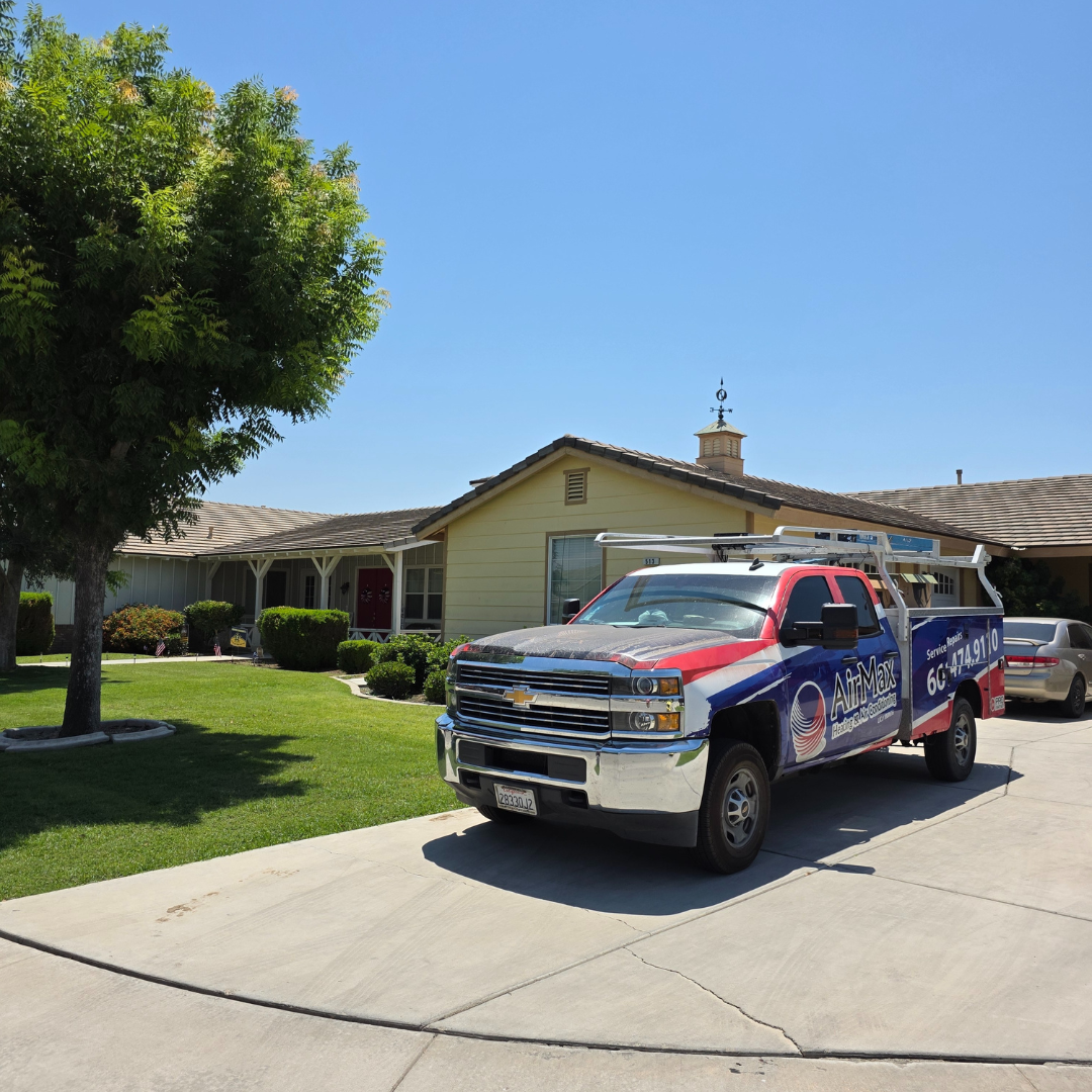 A red white and blue truck is parked in front of a house