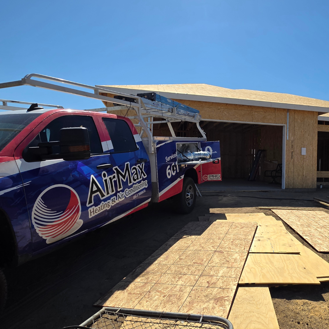 An air max truck is parked in front of a house under construction.