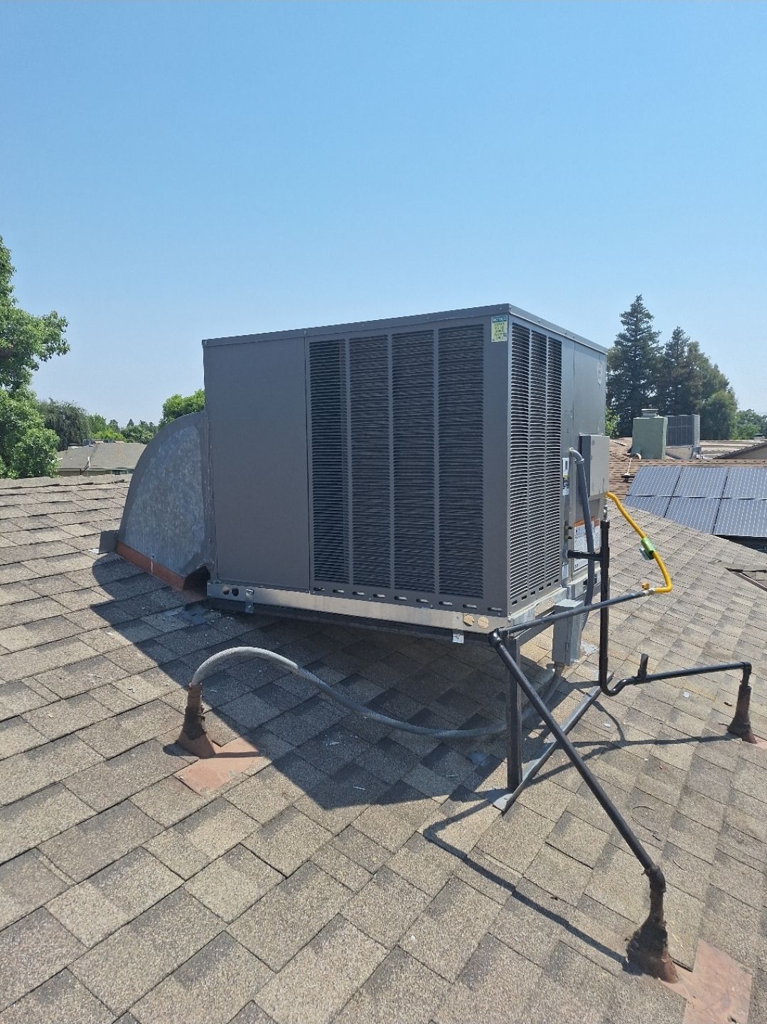 A large air conditioner is sitting on top of a roof.