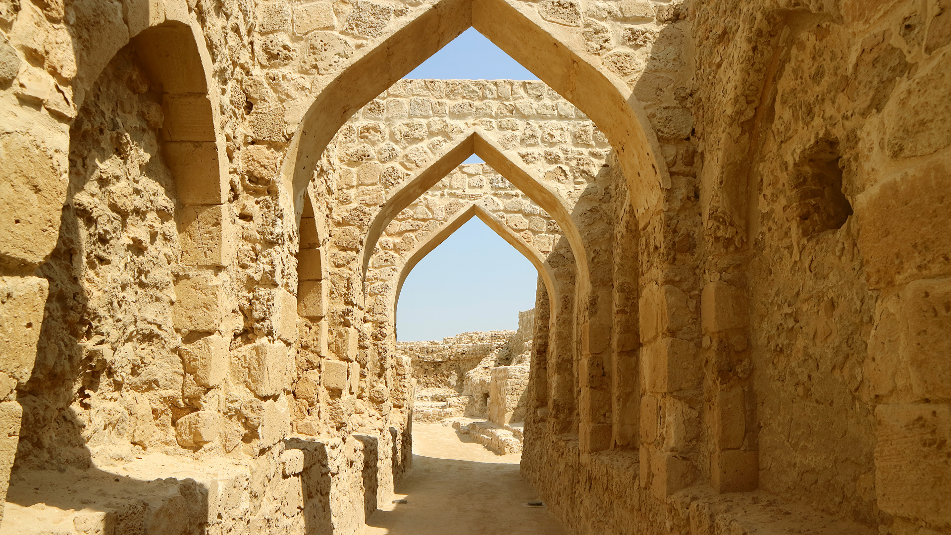A stone archway in the middle of a desert.