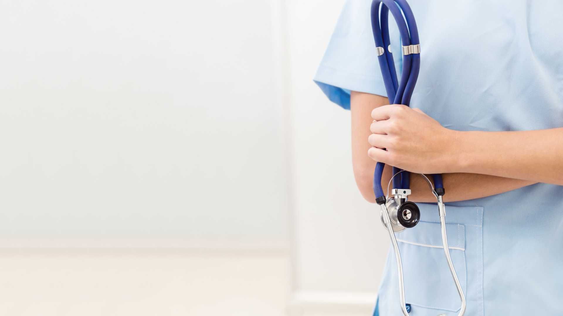 A nurse is holding a stethoscope in her hands.