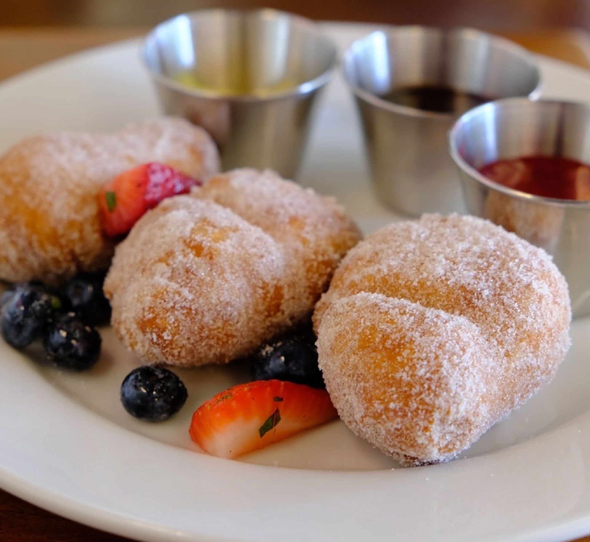 A white plate topped with doughnuts and berries