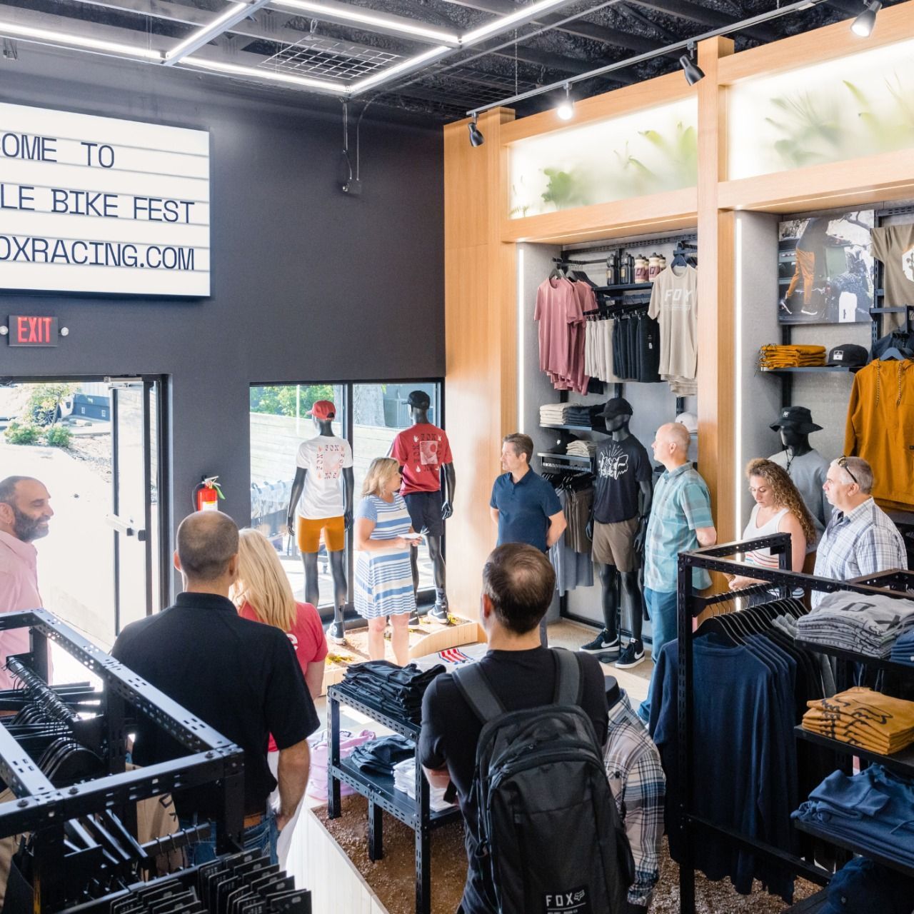 A group of people are standing in a clothing store.