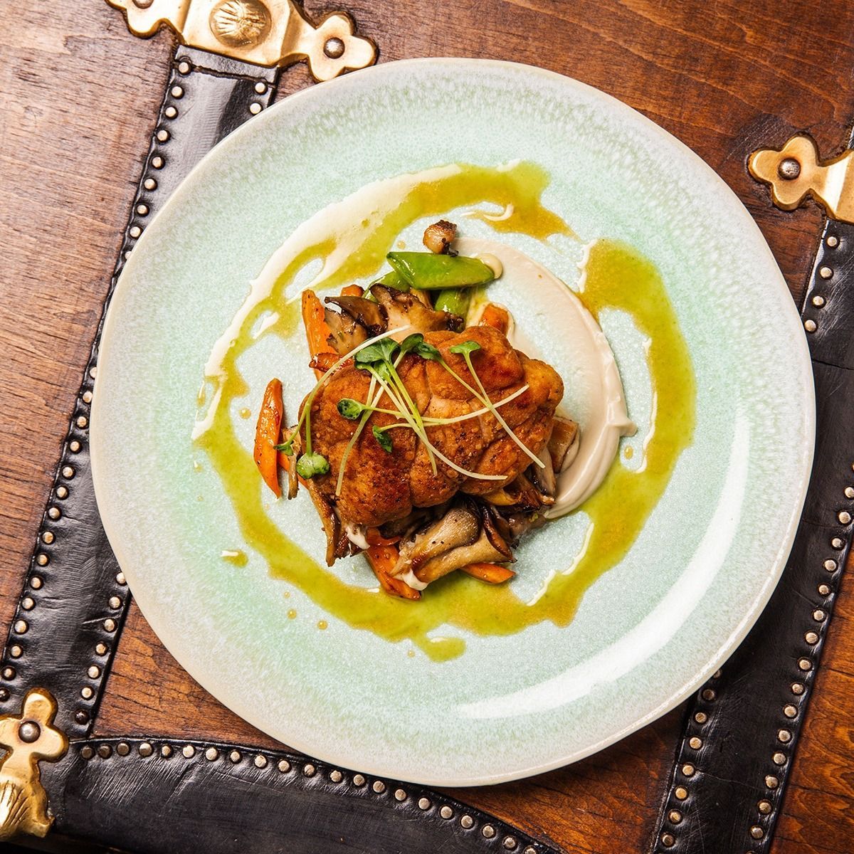 A plate of food with sauce and vegetables on a table