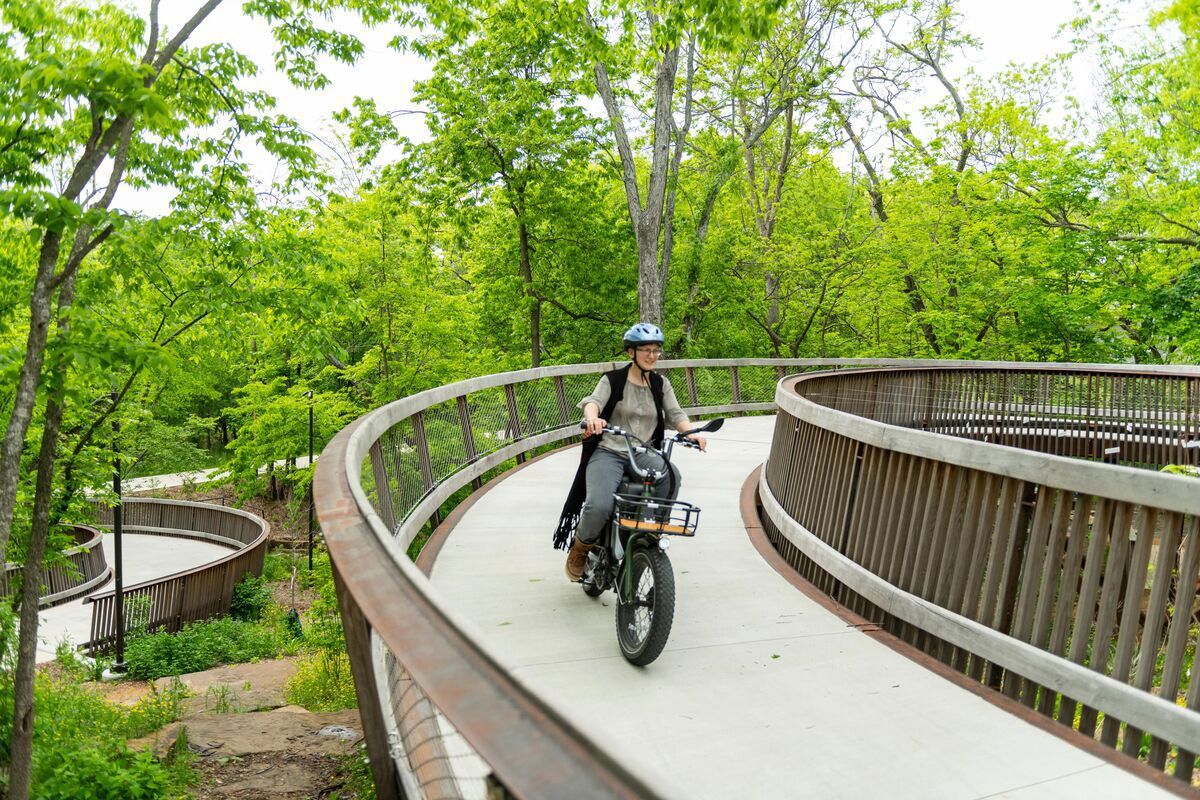 A person is riding a bicycle on a wooden bridge.