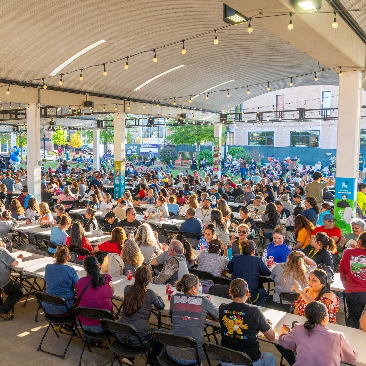 A large group of people are sitting at tables in a public area