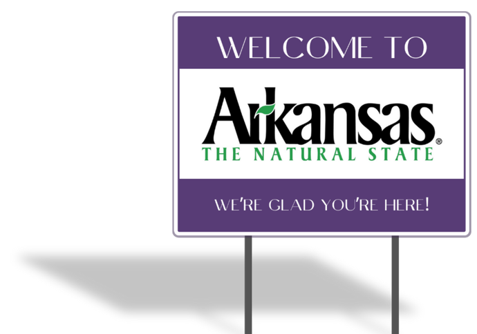 A purple sign that says welcome to arkansas the natural state