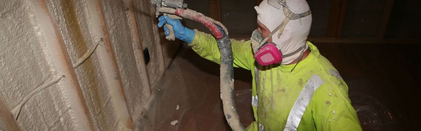 photo of a Tulsa spray foam tech demonstrating application of spray foam insulation