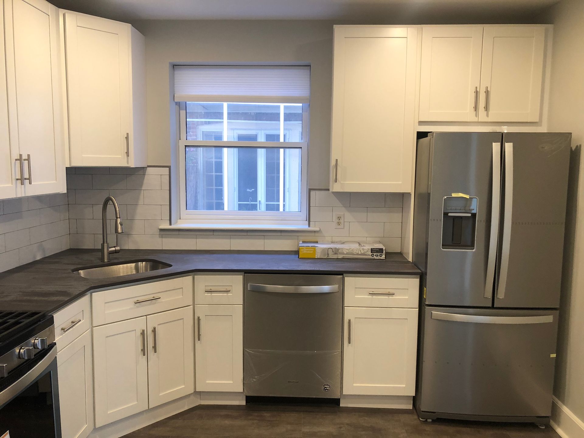 A kitchen with stainless steel appliances and white cabinets