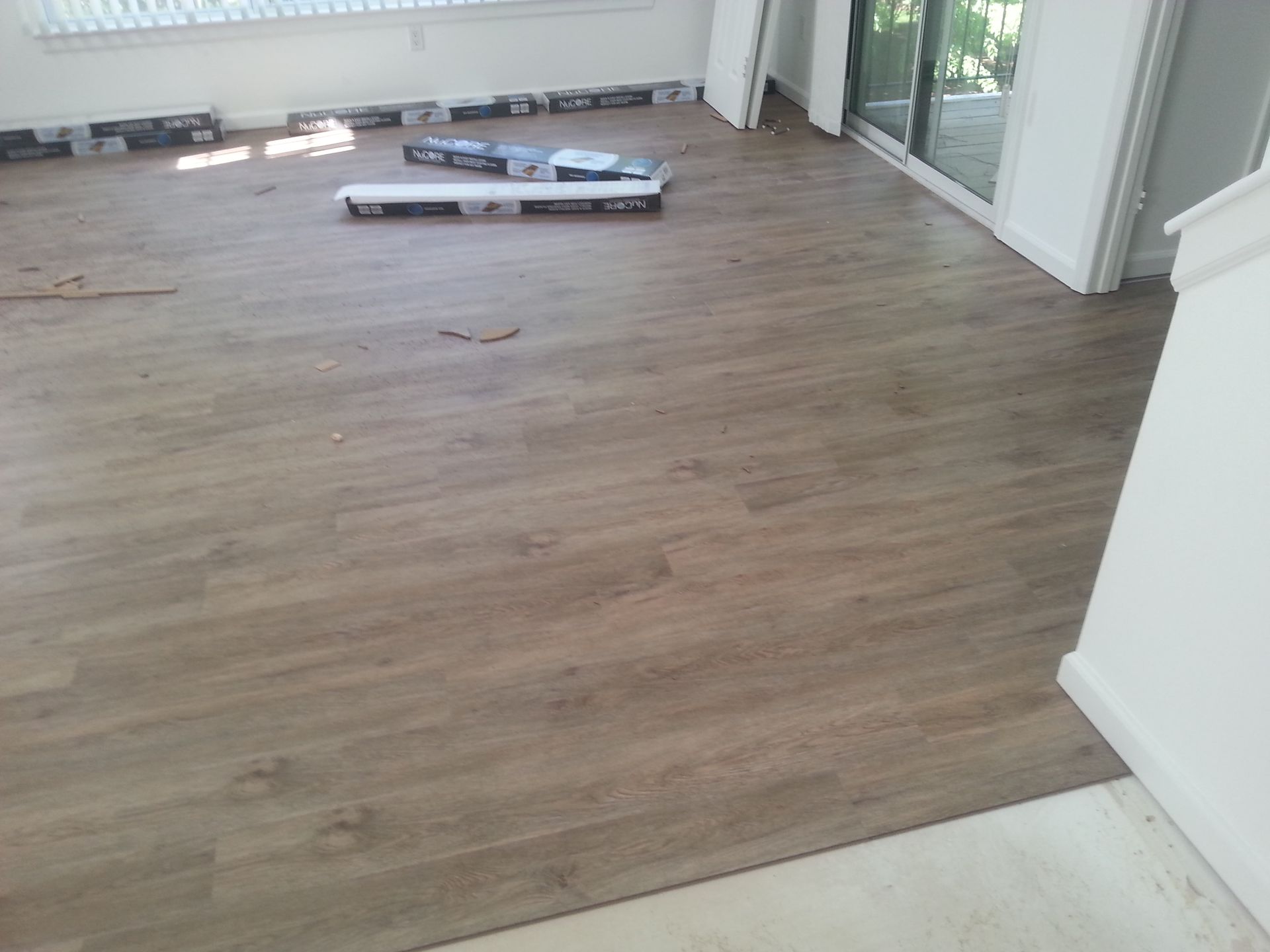 A room with a wooden floor and a sliding glass door.