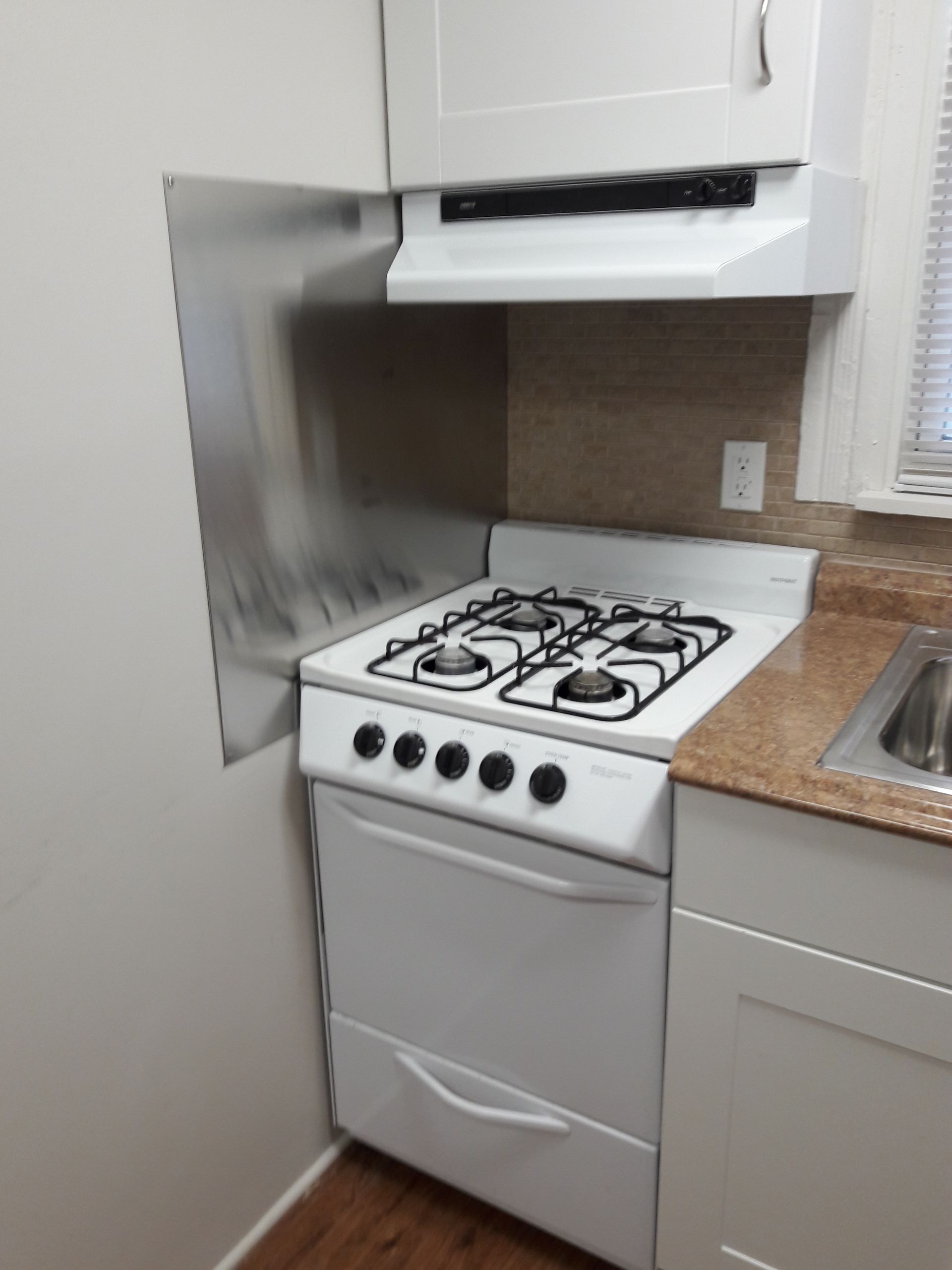 A kitchen with a stove top oven and a sink