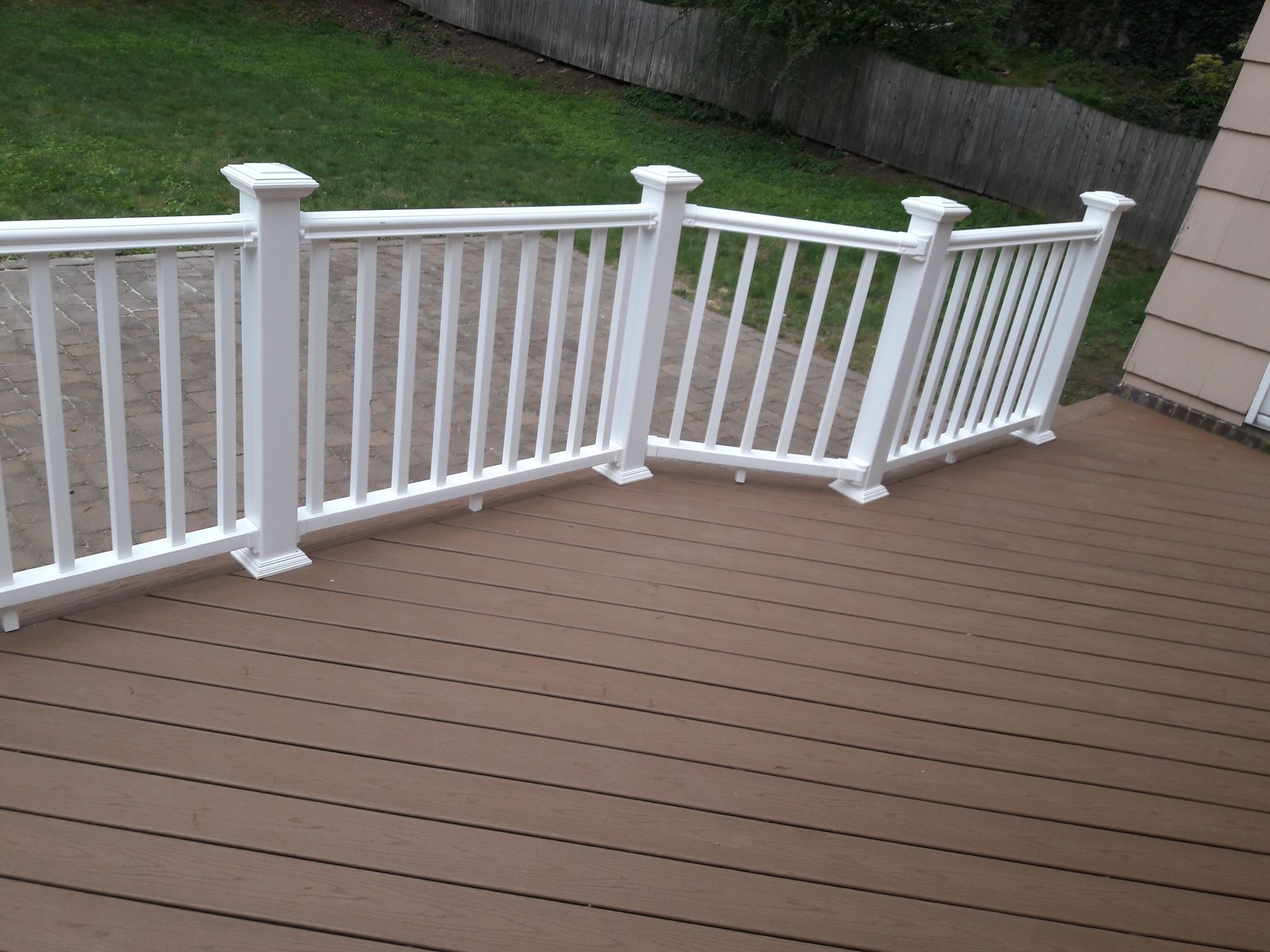 A deck with a white railing and a wooden floor