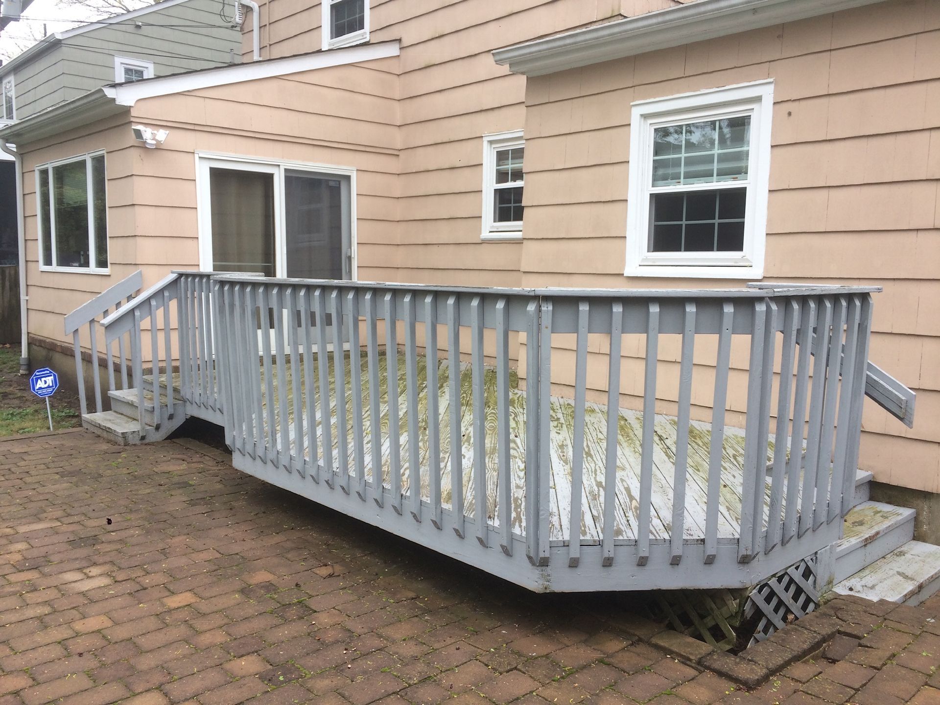 A house with a deck and stairs in front of it