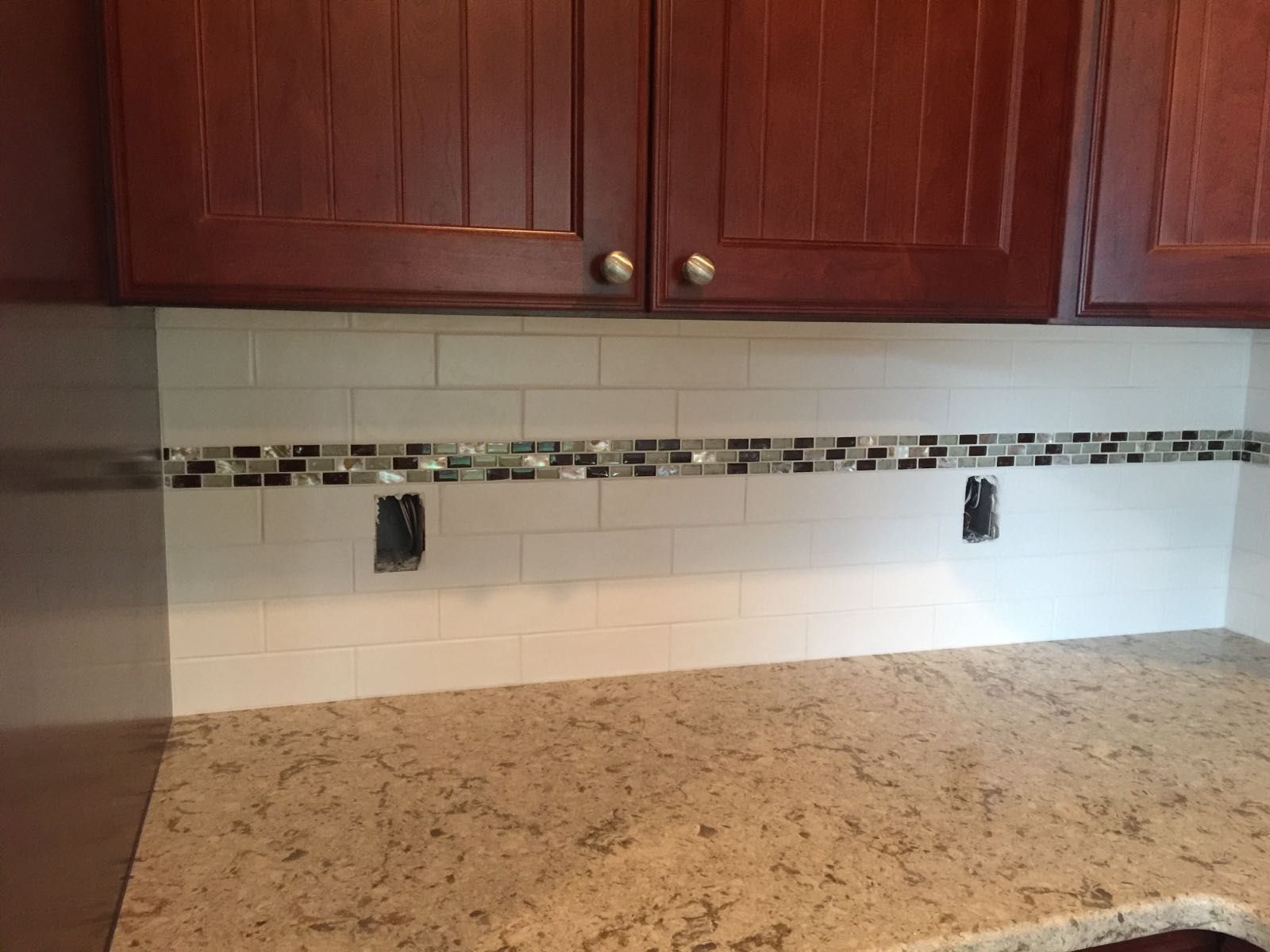 A kitchen with wooden cabinets and a granite counter top.
