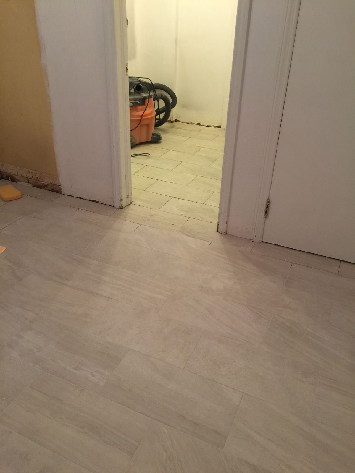 A vacuum cleaner is sitting in a room next to a door.