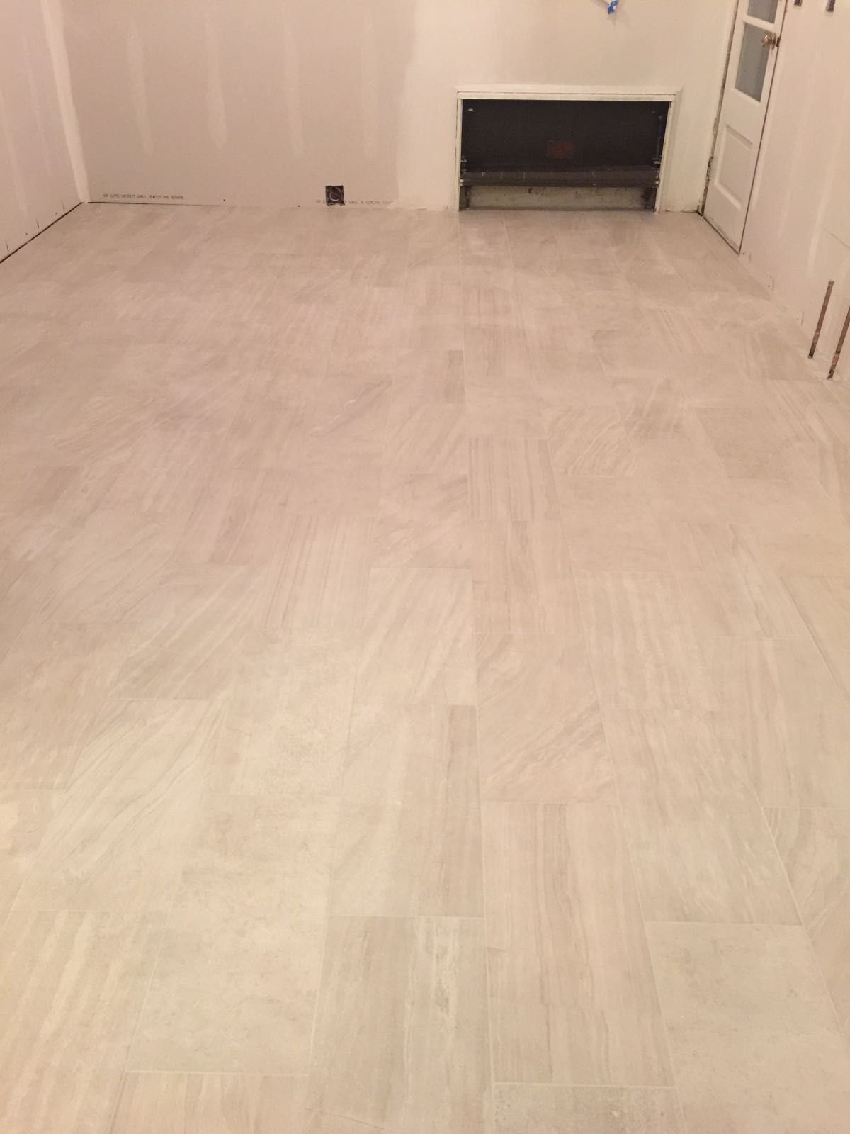 A room with a white tile floor and a fireplace.