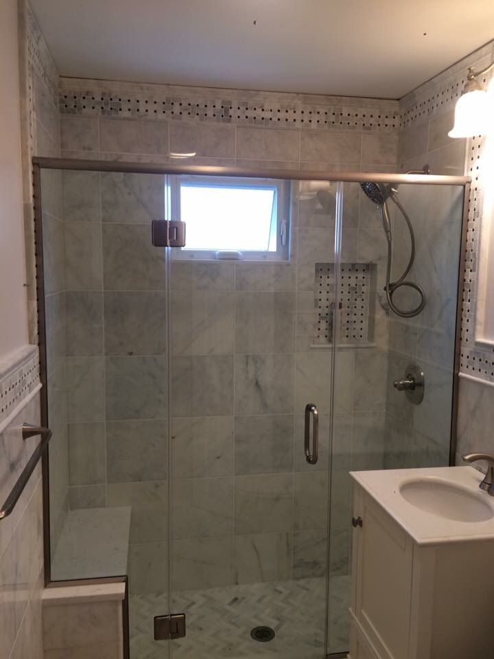 A bathroom with a sliding glass shower door and a sink.