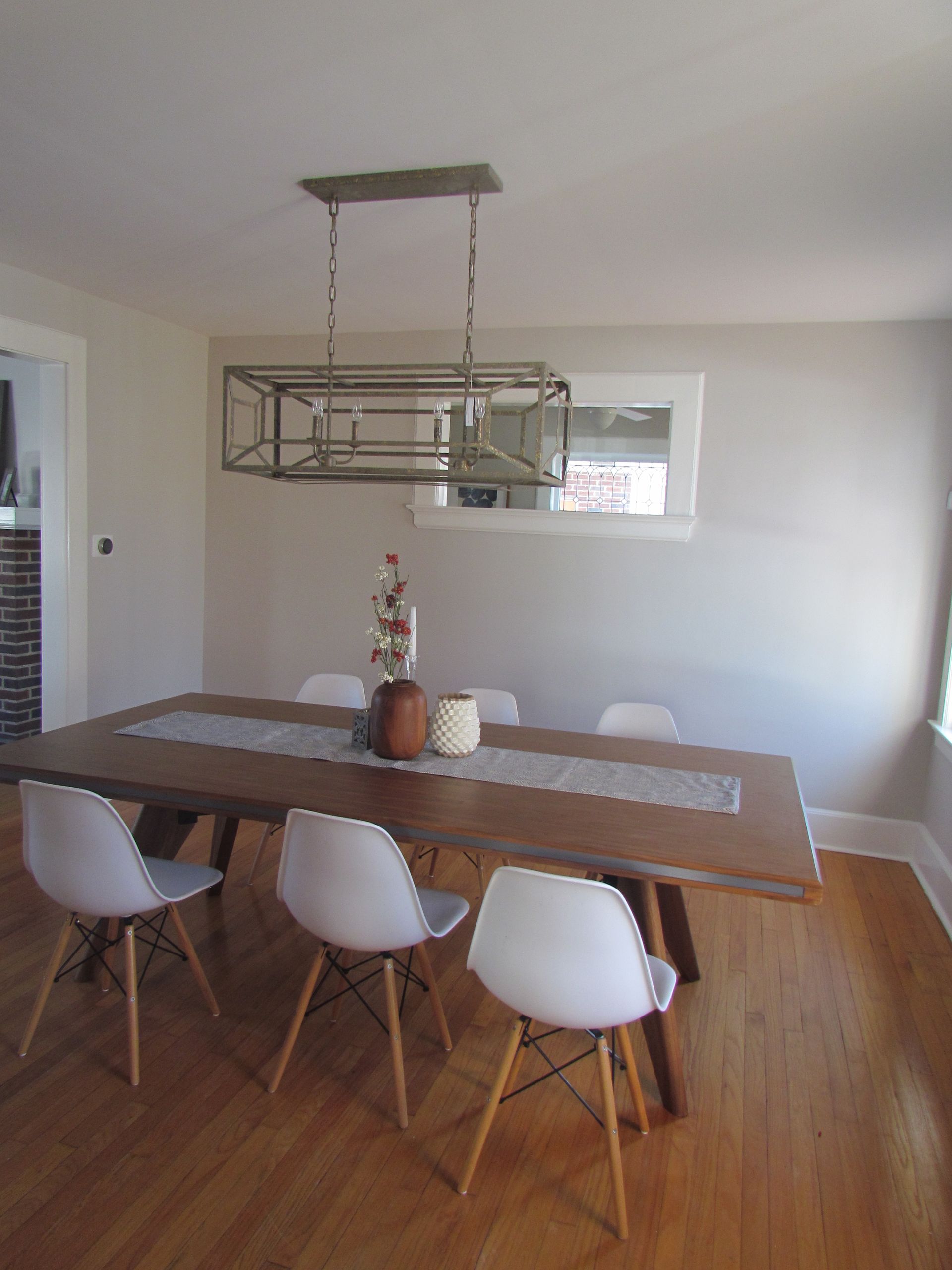 A dining room with a wooden table and white chairs