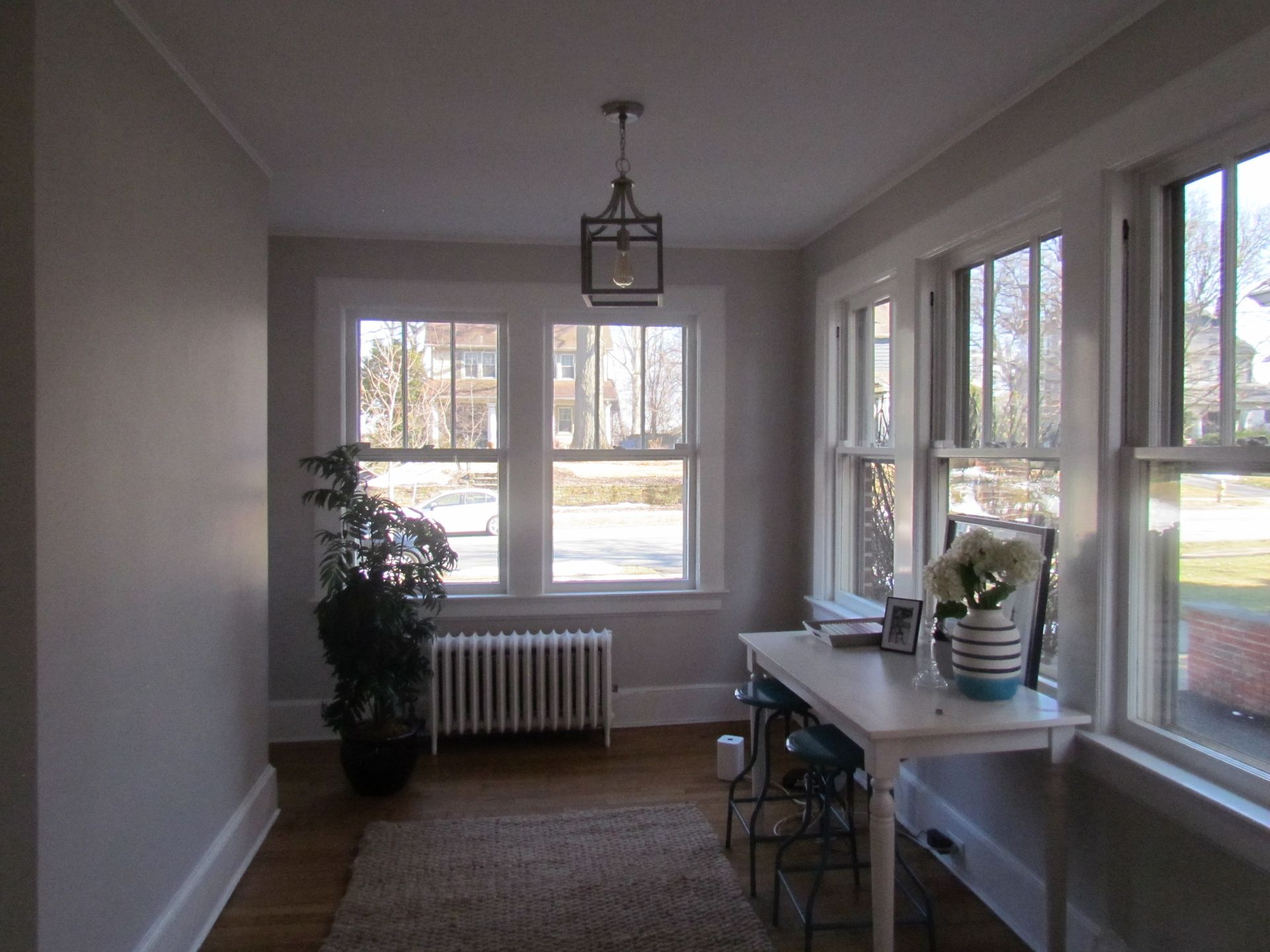 A room with a table and chairs and many windows