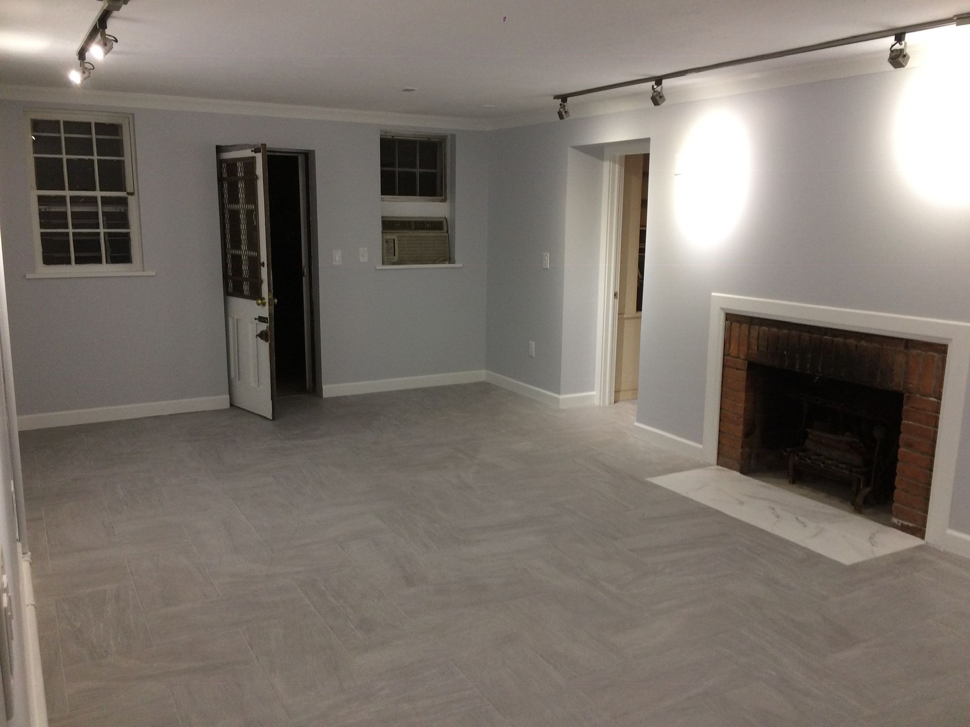 An empty living room with a fireplace and a door