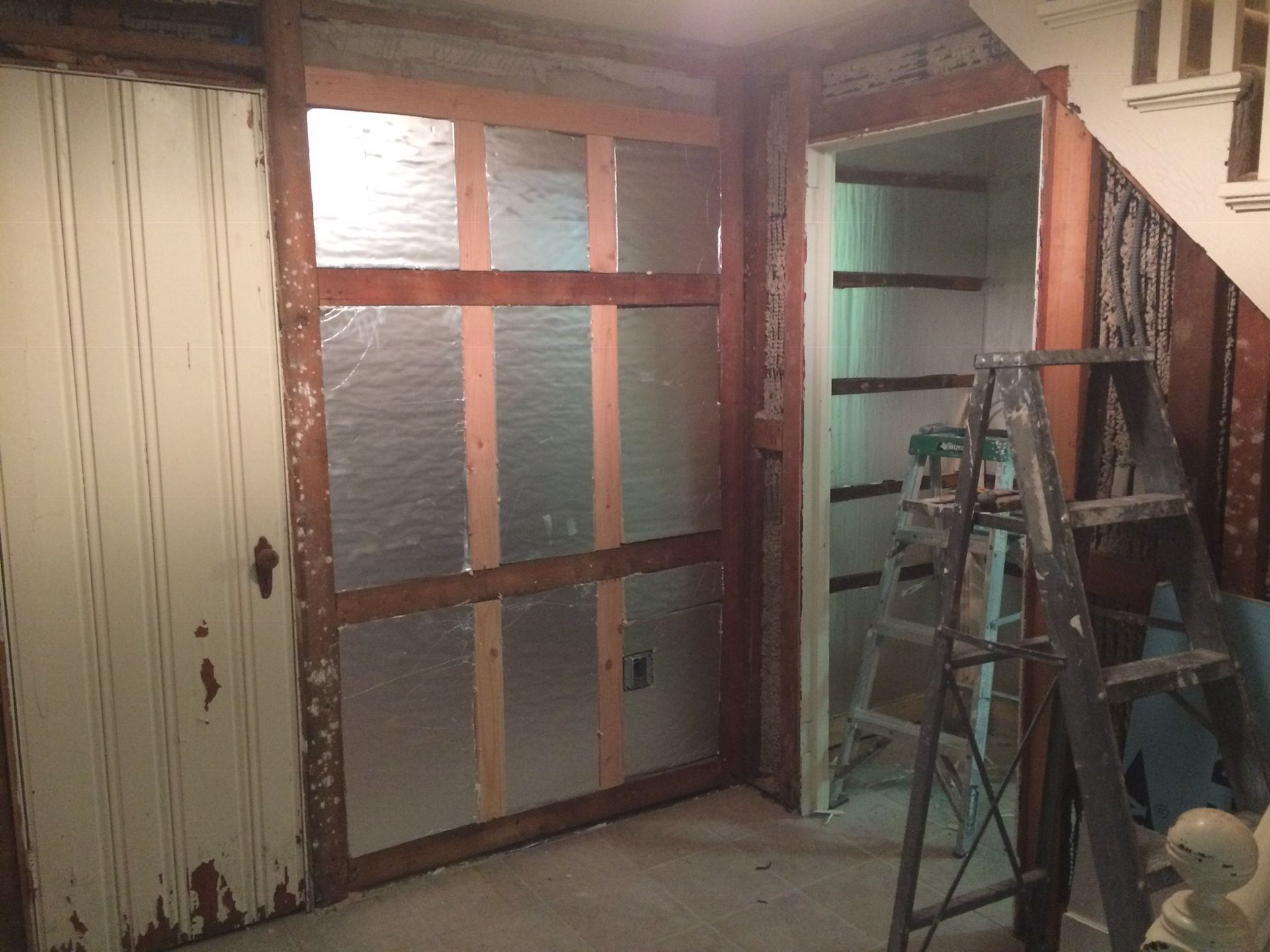 A ladder is sitting in a room next to a door.