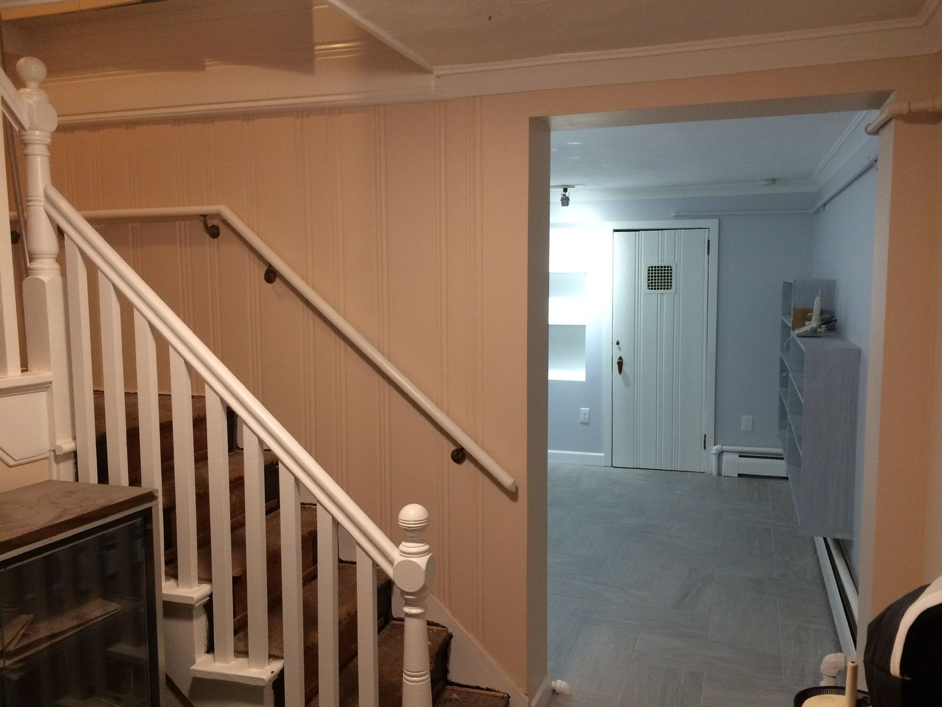 A staircase leading up to a basement with a white railing