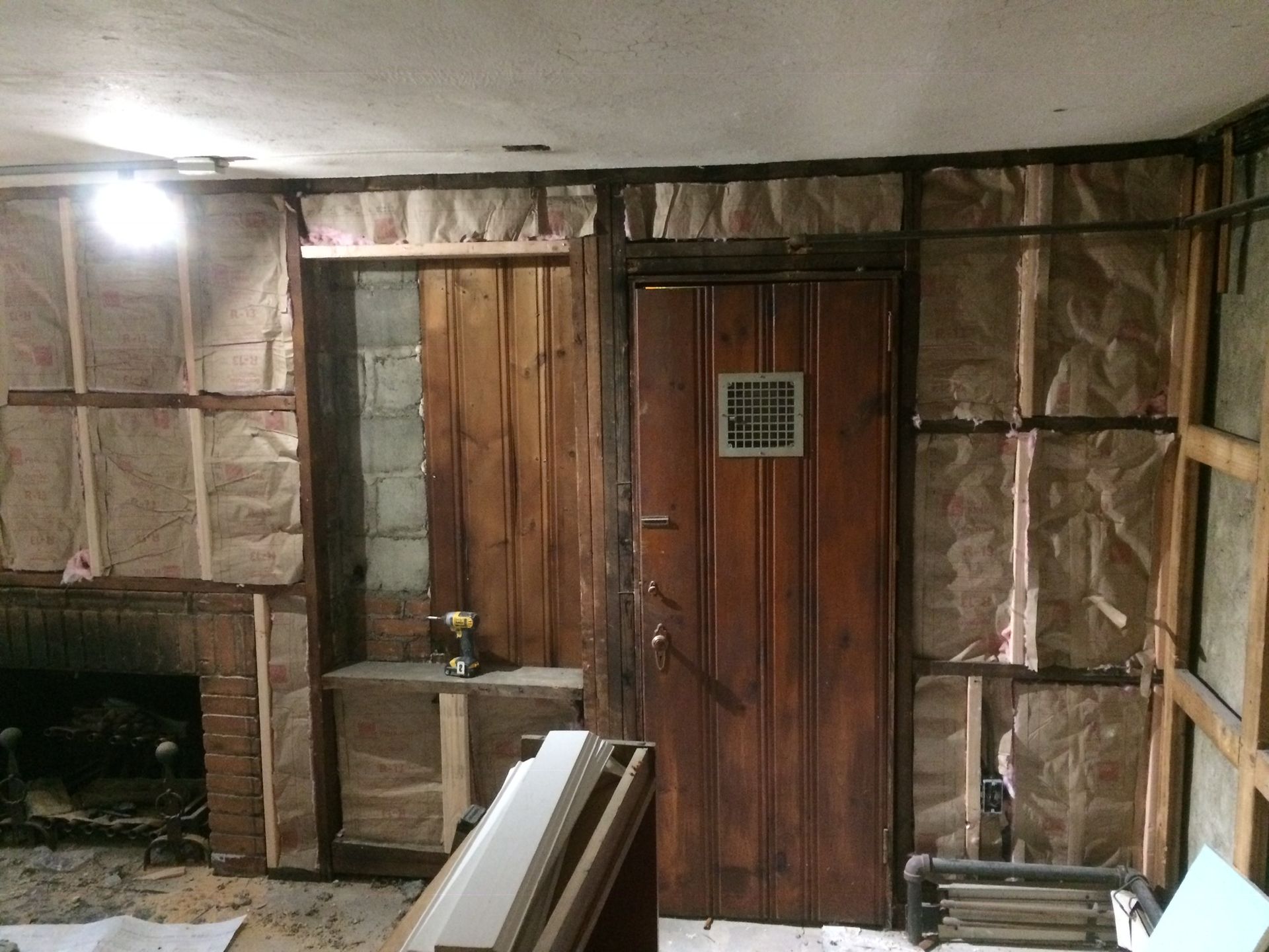 A room with a wooden door and a brick fireplace