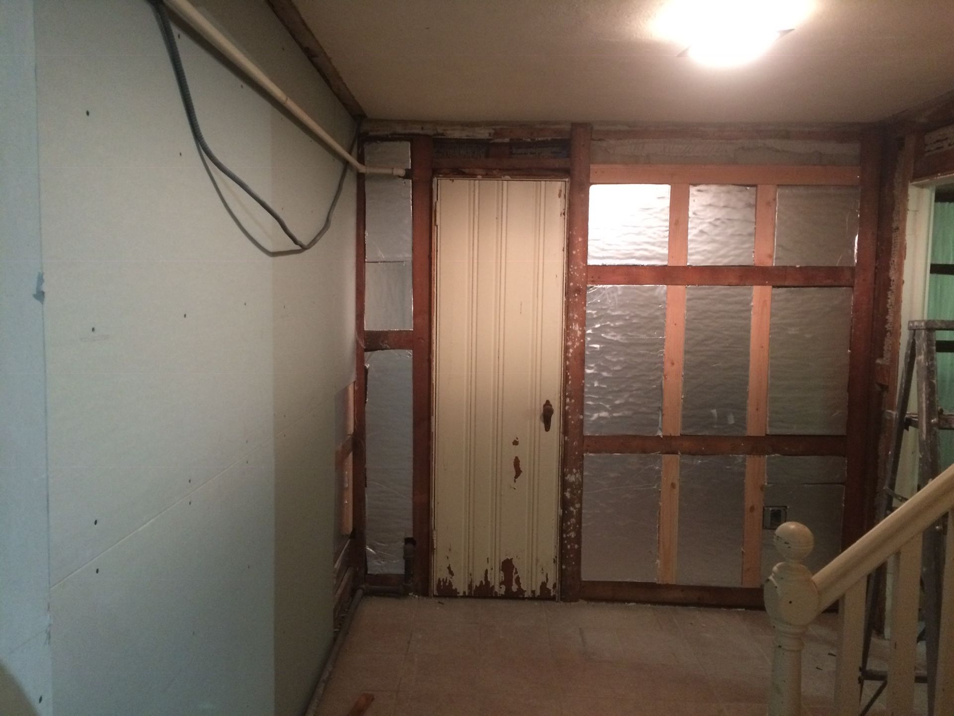 A room with a door and a staircase in it