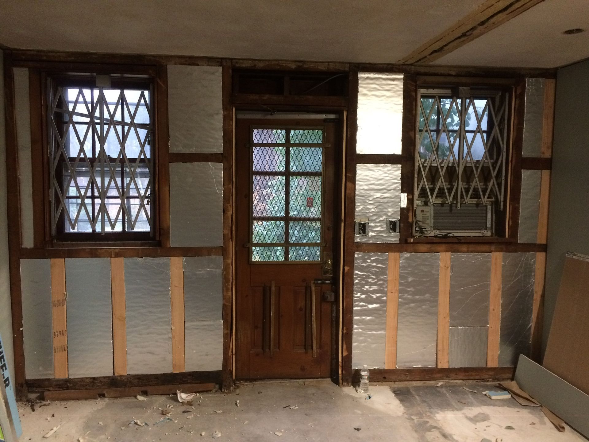 An empty room with a door and two windows
